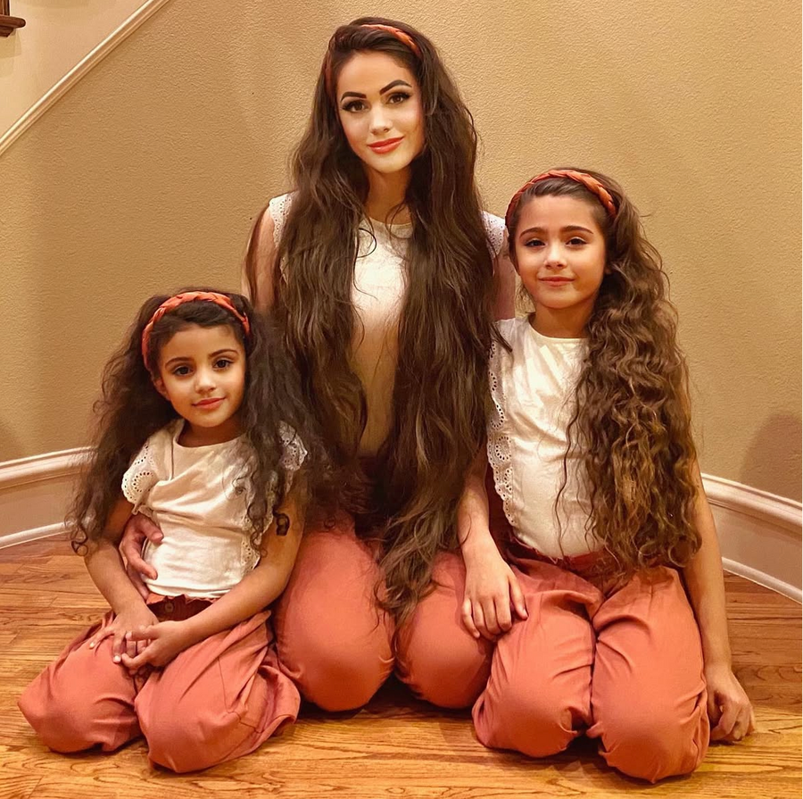 Ariana and her daughters wearing coordinated coral-peach outfits