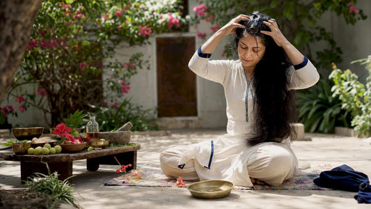 Woman performing traditional hair oiling ritual