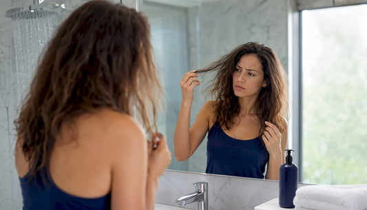 Woman showing damaged hair in shower