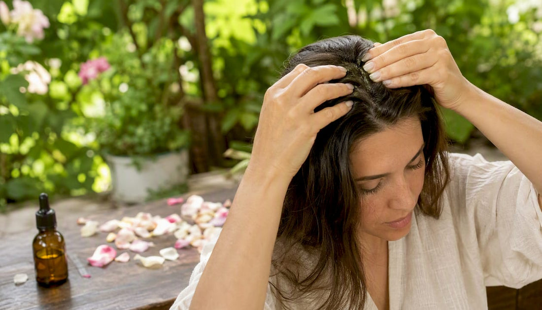 Hands massaging jojoba oil into scalp and hair