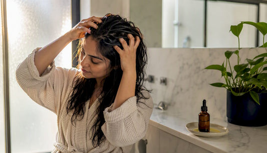 Hands massaging bhringraj oil into scalp