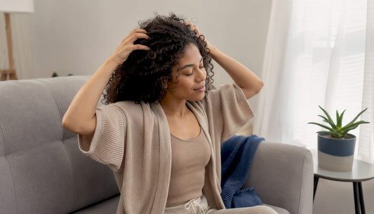 Person massaging scalp in natural light