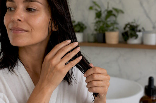 Woman applying hair oil drops to damp hair