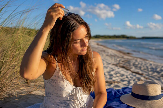 Woman applying scalp SPF stick on hair part
