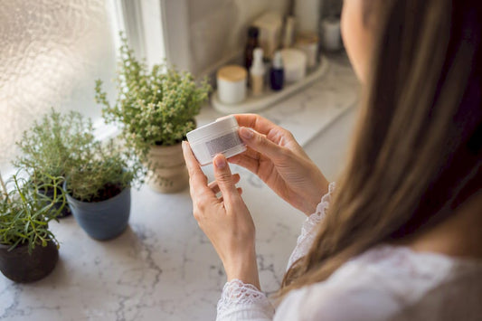Hands reading skincare ingredient label