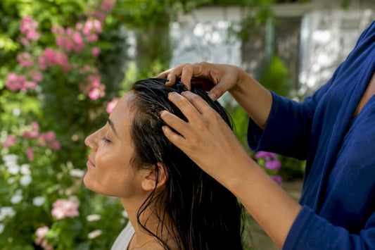 Hands massaging plant-based oil into scalp