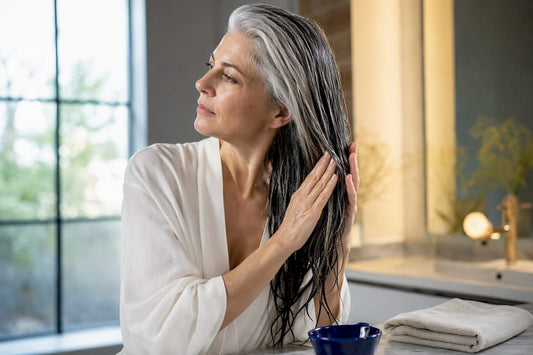 Woman smoothing moisture through gray hair