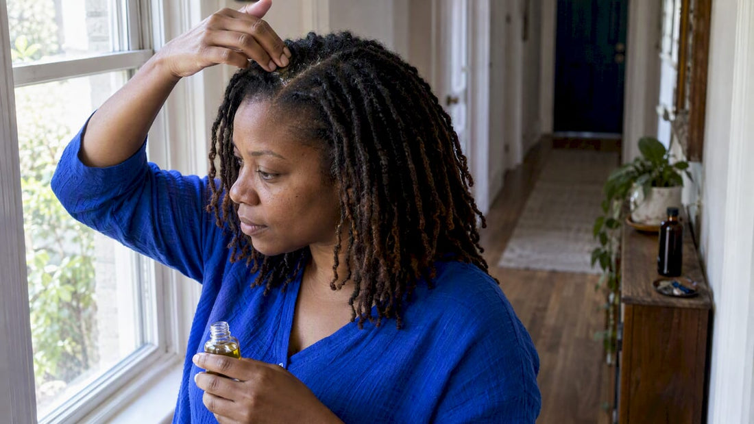 Woman applying oil directly to loc scalp