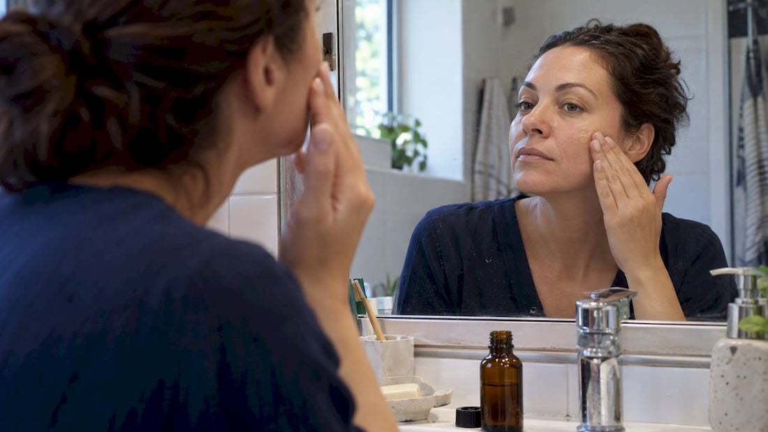 Woman applying jojoba oil to her cheek