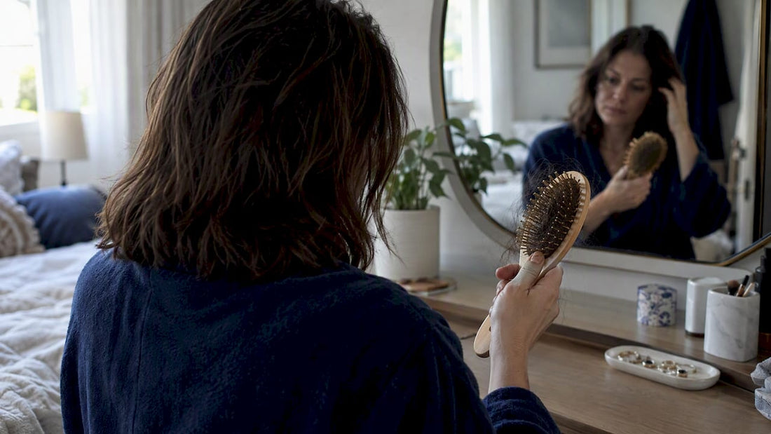 Woman noticing shed hair in her brush