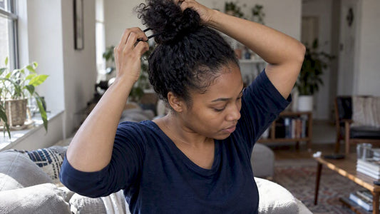 Woman loosening a tightly pulled high bun